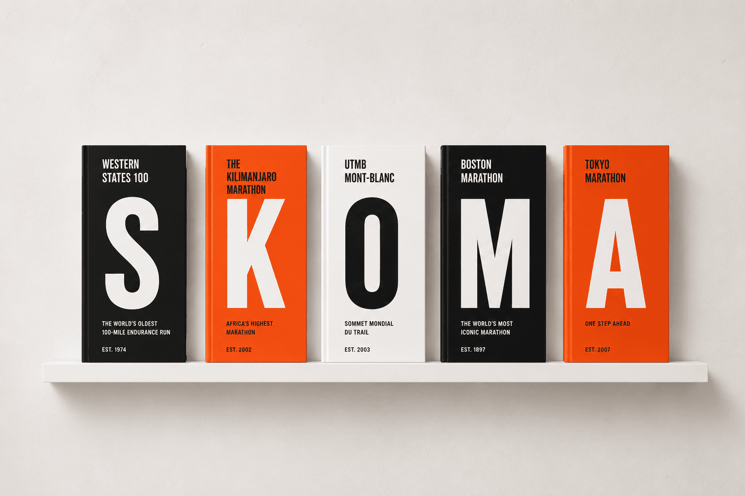 A shelf of finished Skoma photo books, their spines spelling SKOMA, each a hardcover for an iconic race